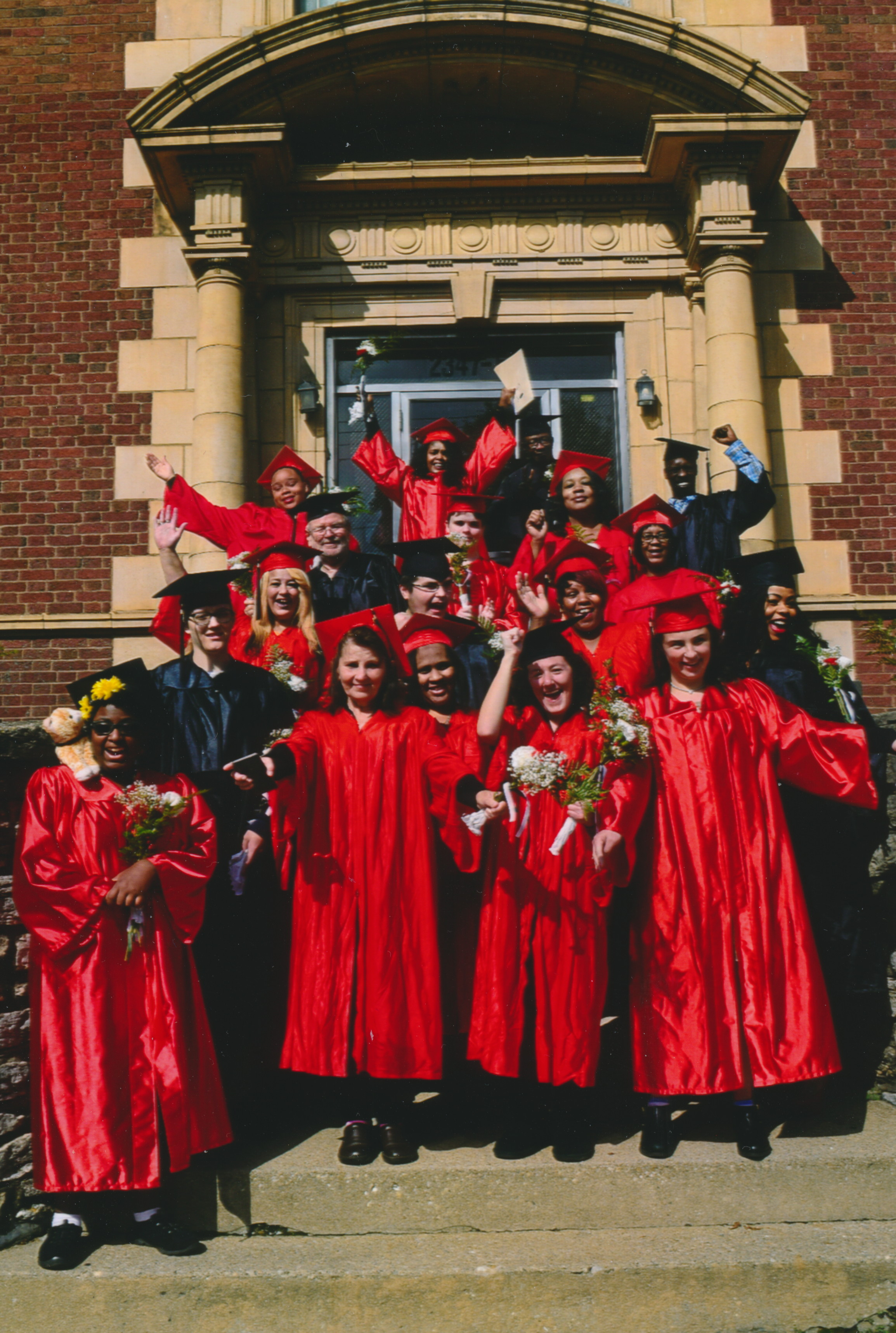 People standing in red graduation gowns